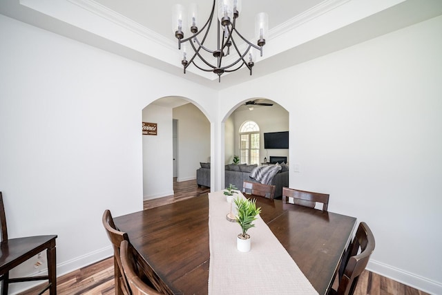 dining room with hardwood / wood-style flooring, ceiling fan with notable chandelier, and ornamental molding