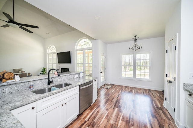 kitchen with dishwasher, sink, white cabinetry, light stone counters, and wood-type flooring