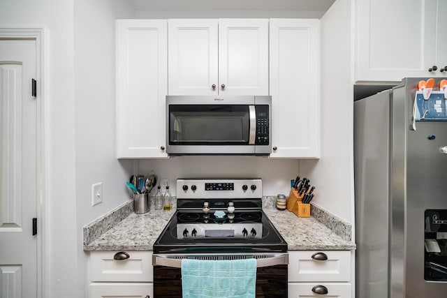 kitchen featuring white cabinetry, light stone countertops, and appliances with stainless steel finishes