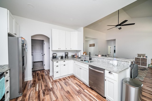 kitchen with kitchen peninsula, white cabinetry, sink, and stainless steel appliances