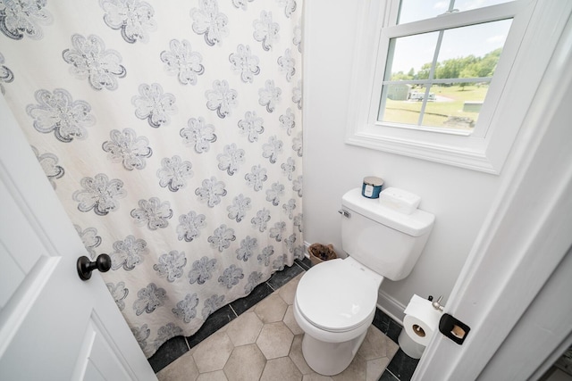 bathroom with tile patterned floors, a shower with shower curtain, and toilet