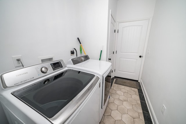 clothes washing area with light tile patterned flooring and independent washer and dryer