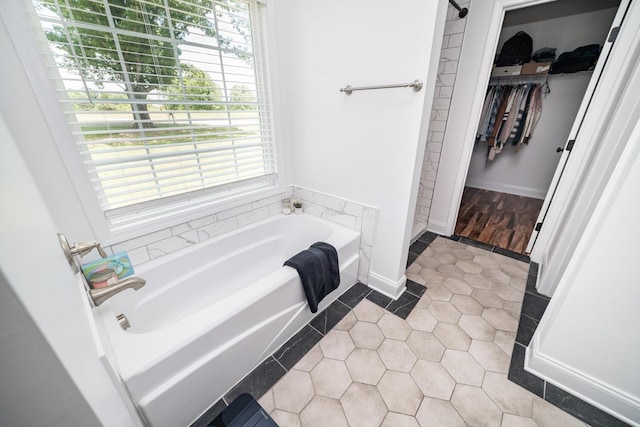 bathroom with tile patterned floors and a tub