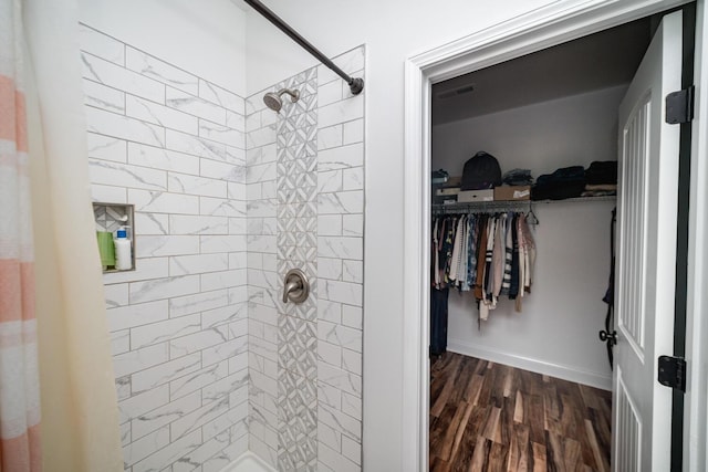 bathroom with hardwood / wood-style floors and tiled shower