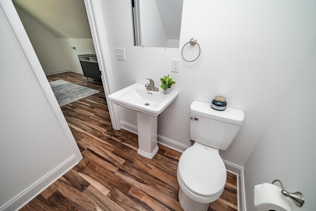 bathroom with toilet, wood-type flooring, and vaulted ceiling