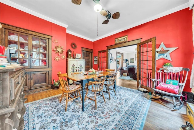 dining area with crown molding, hardwood / wood-style floors, ceiling fan, and french doors