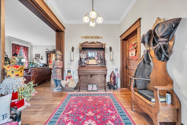 interior space featuring a chandelier, light hardwood / wood-style floors, and ornamental molding