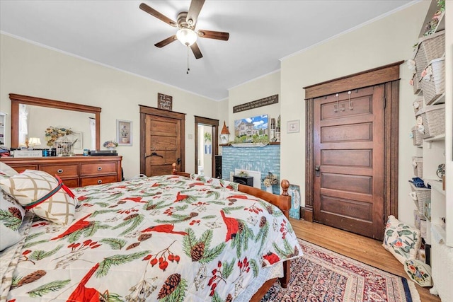 bedroom with light hardwood / wood-style floors, ceiling fan, and ornamental molding