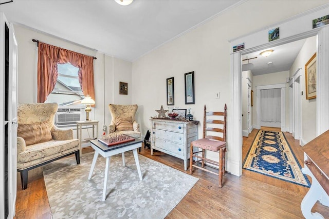 sitting room with crown molding and wood-type flooring