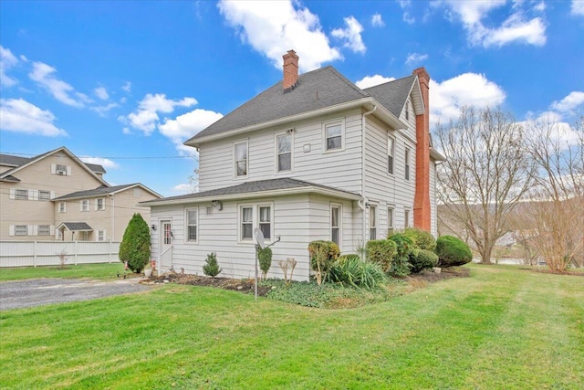 rear view of house featuring a lawn