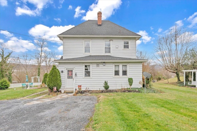 rear view of house featuring a yard