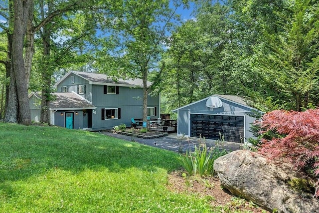 rear view of house featuring a lawn, a wooden deck, and a garage