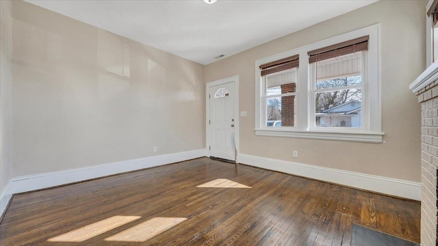 unfurnished room with dark wood-type flooring and baseboards