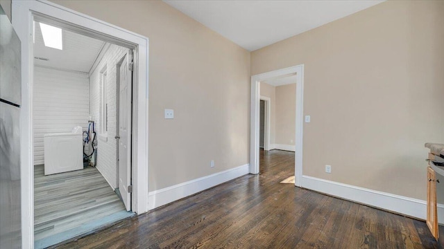 spare room with baseboards and wood finished floors