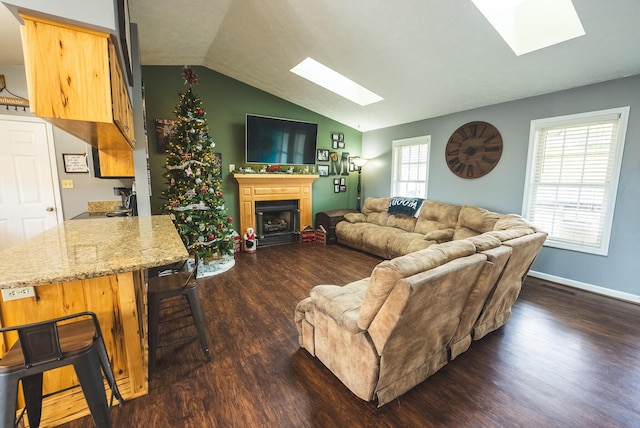 living room featuring sink, dark hardwood / wood-style flooring, and vaulted ceiling with skylight