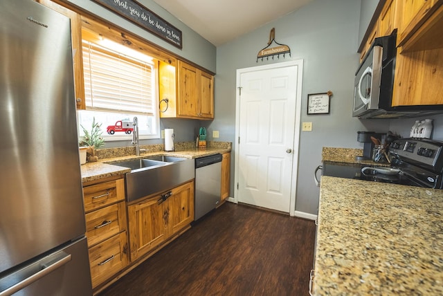 kitchen featuring light stone counters, stainless steel appliances, vaulted ceiling, sink, and dark hardwood / wood-style floors