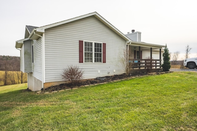 view of side of property with covered porch and a yard