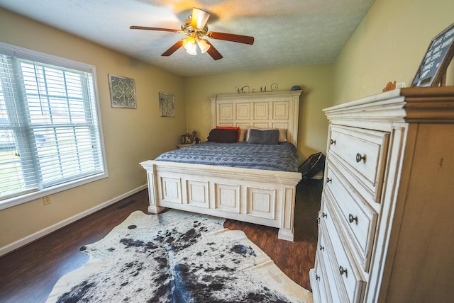 bedroom featuring a textured ceiling, ceiling fan, and dark wood-type flooring