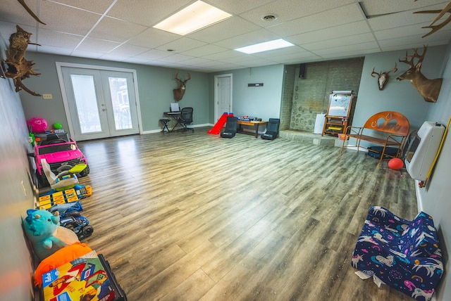 rec room featuring hardwood / wood-style floors, a drop ceiling, and french doors