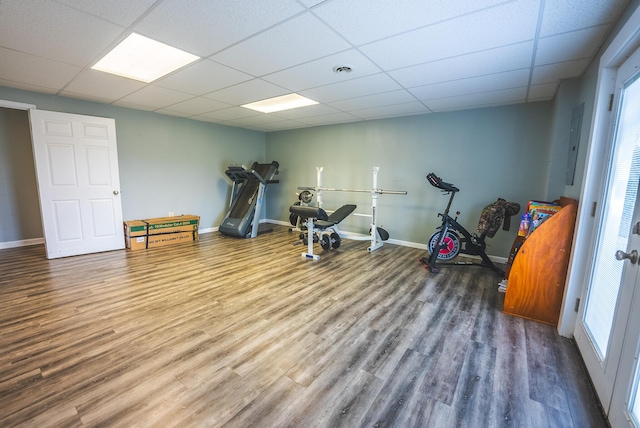 exercise area with a paneled ceiling and wood-type flooring