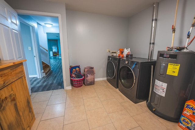 laundry room with light tile patterned floors, separate washer and dryer, and water heater