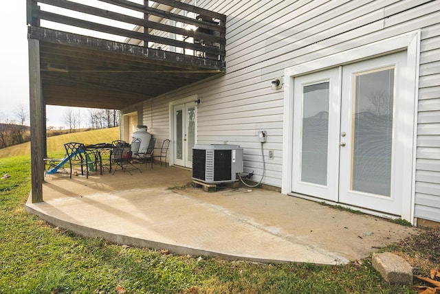 view of patio / terrace with central air condition unit, a wooden deck, and french doors