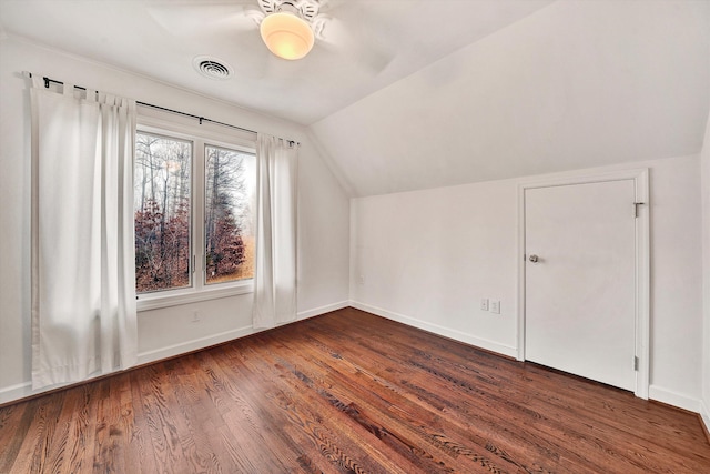 additional living space with dark wood-type flooring and vaulted ceiling