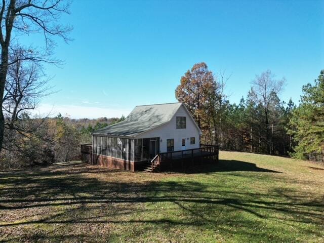 exterior space with a sunroom, a yard, and a deck