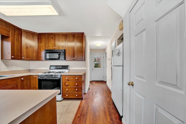 kitchen with white appliances, light hardwood / wood-style flooring, and sink