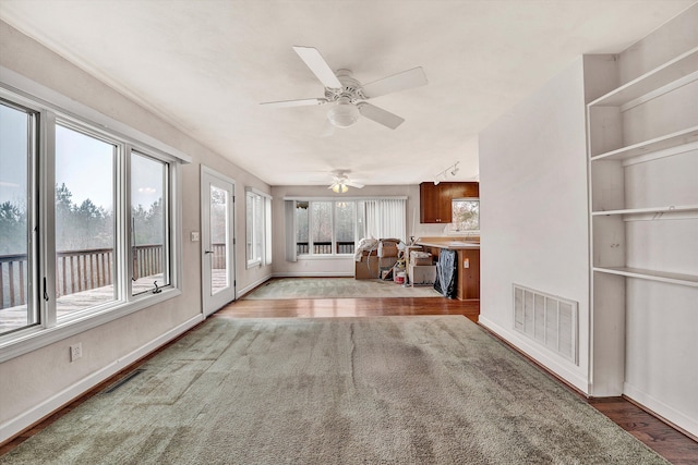 unfurnished sunroom featuring ceiling fan