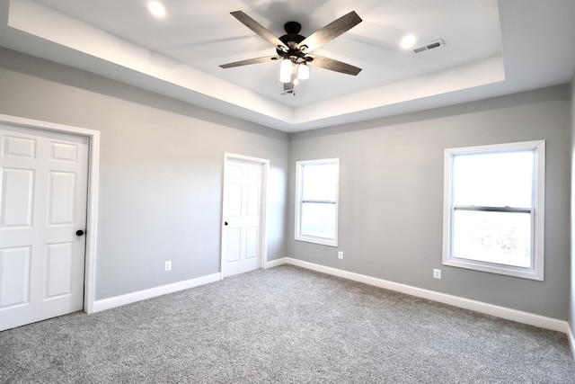 unfurnished room featuring carpet, a raised ceiling, and ceiling fan