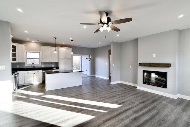 kitchen with white cabinets, a center island, pendant lighting, and dark hardwood / wood-style flooring