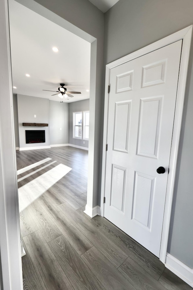 unfurnished living room with dark hardwood / wood-style floors and ceiling fan