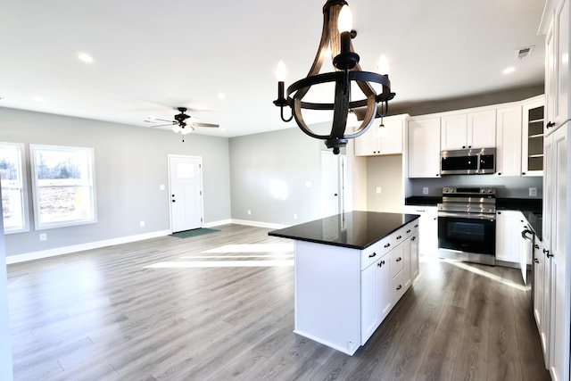 kitchen with white cabinetry, a kitchen island, wood-type flooring, and appliances with stainless steel finishes