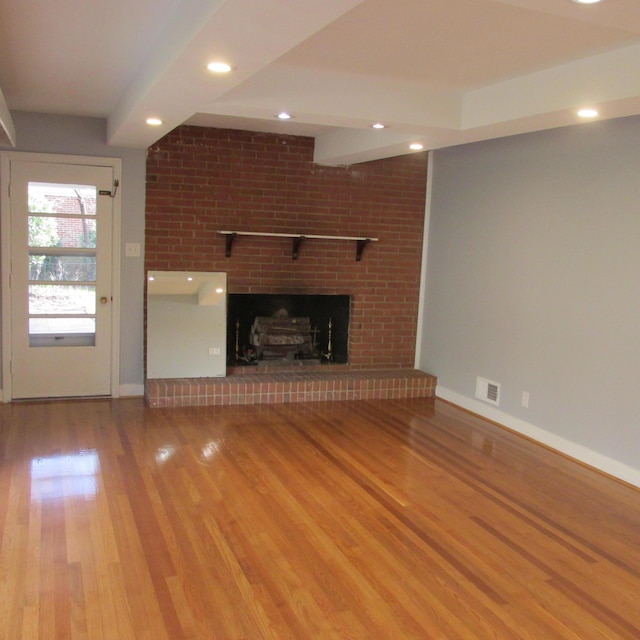 unfurnished living room featuring hardwood / wood-style flooring and a fireplace