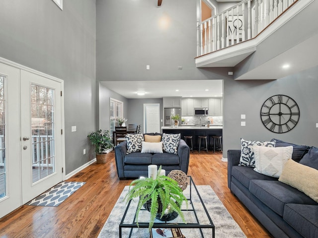 living room featuring light hardwood / wood-style flooring and a high ceiling