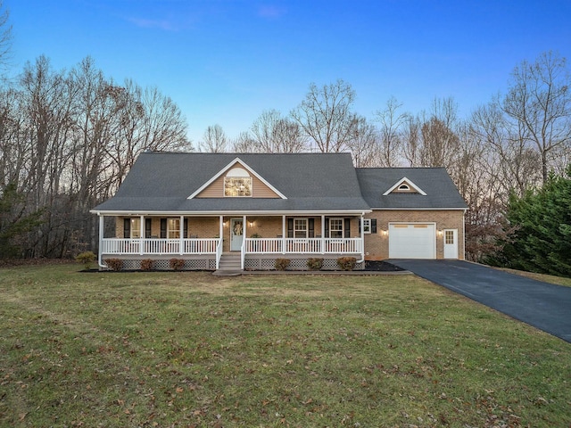 country-style home with covered porch, a garage, and a front yard