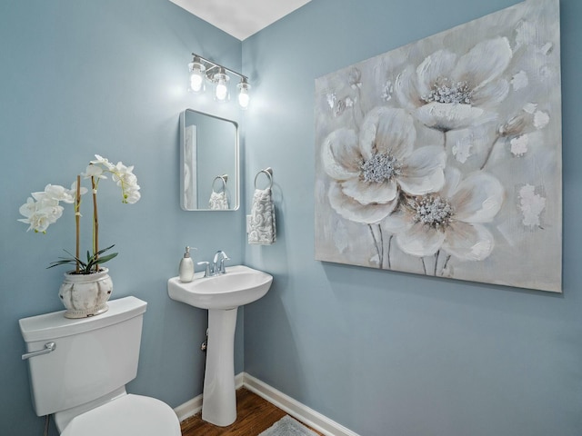 bathroom with hardwood / wood-style floors, toilet, and sink