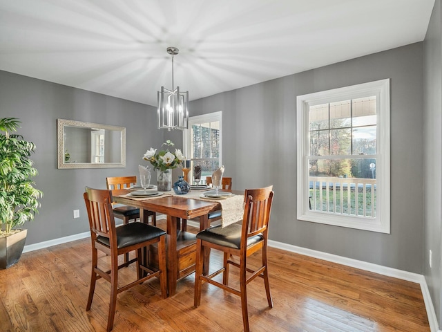 dining area with an inviting chandelier, a healthy amount of sunlight, and light hardwood / wood-style floors