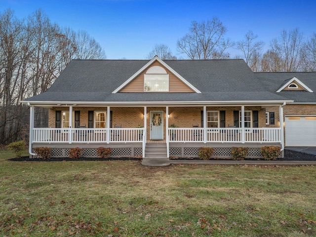 farmhouse featuring a front lawn, a porch, and a garage