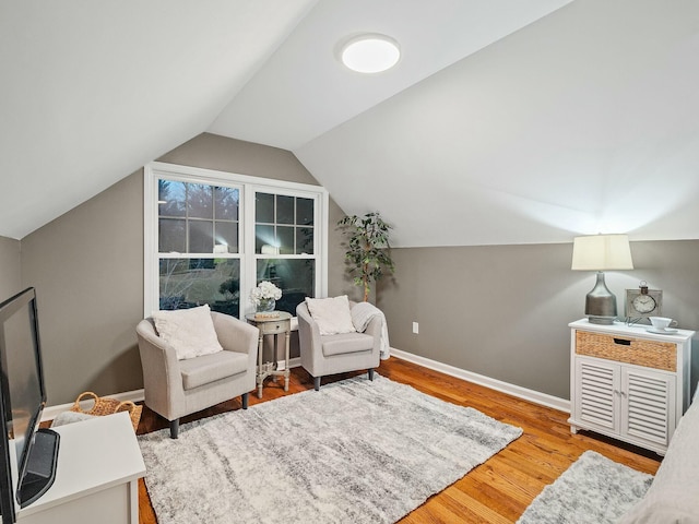 living area featuring hardwood / wood-style floors and vaulted ceiling