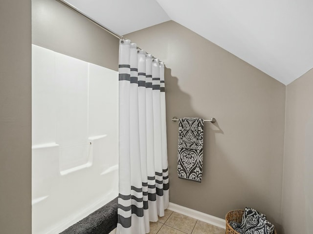 bathroom with tile patterned flooring, lofted ceiling, and a shower with shower curtain