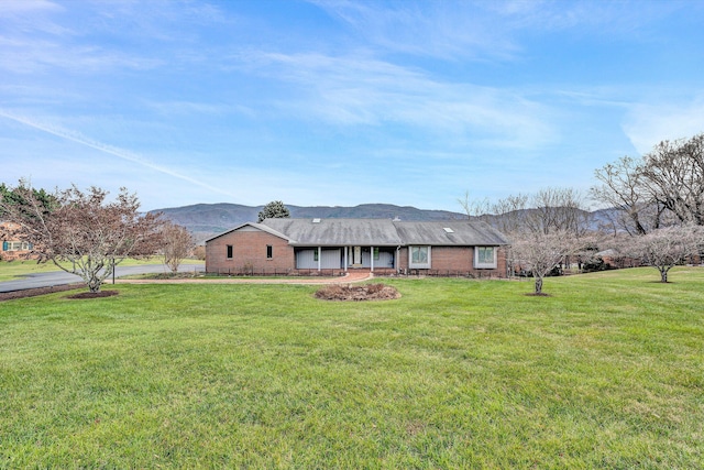 view of front of property featuring a mountain view and a front lawn