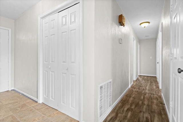 hallway featuring visible vents and baseboards