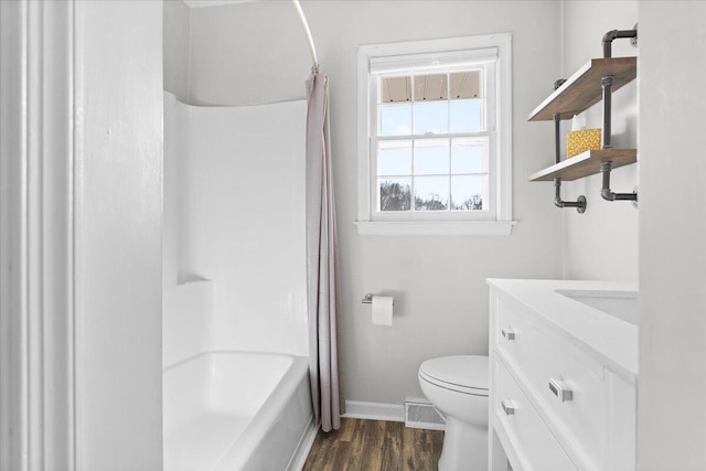 bathroom with visible vents, toilet, vanity, wood finished floors, and baseboards