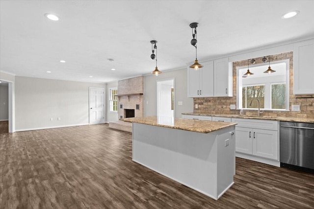 kitchen featuring stainless steel dishwasher, dark wood-type flooring, a sink, and decorative backsplash