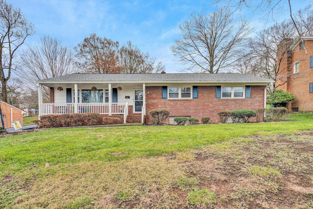 ranch-style home with covered porch and a front yard