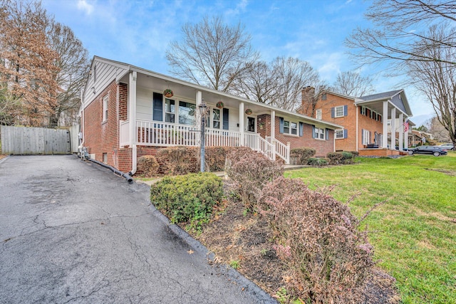 single story home featuring covered porch and a front yard