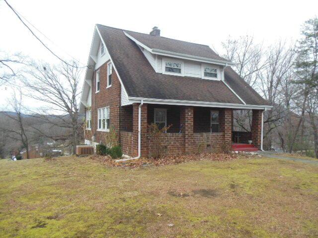 view of front of house with cooling unit and a front lawn