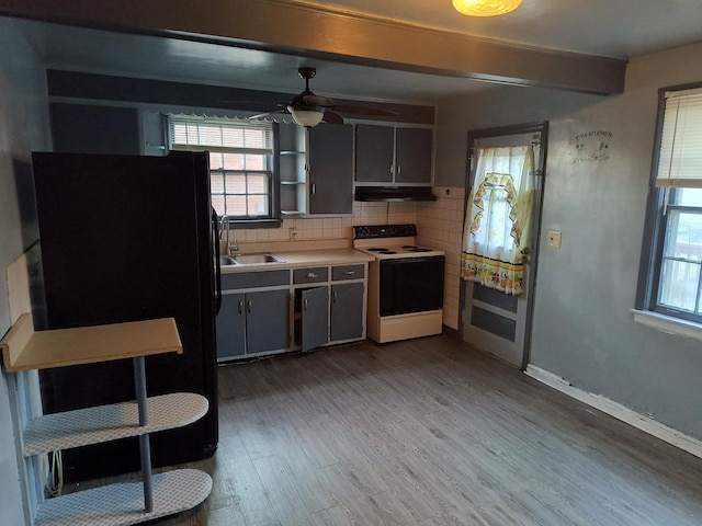 kitchen with black refrigerator, sink, decorative backsplash, electric range, and light hardwood / wood-style flooring